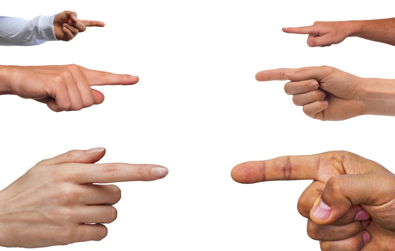 Fingers pointing at each other on a white background