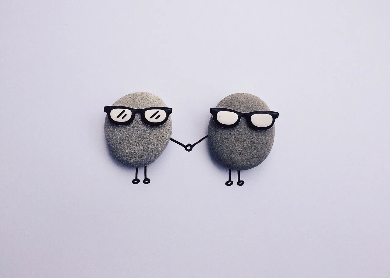 two rocks with glasses supporting each other